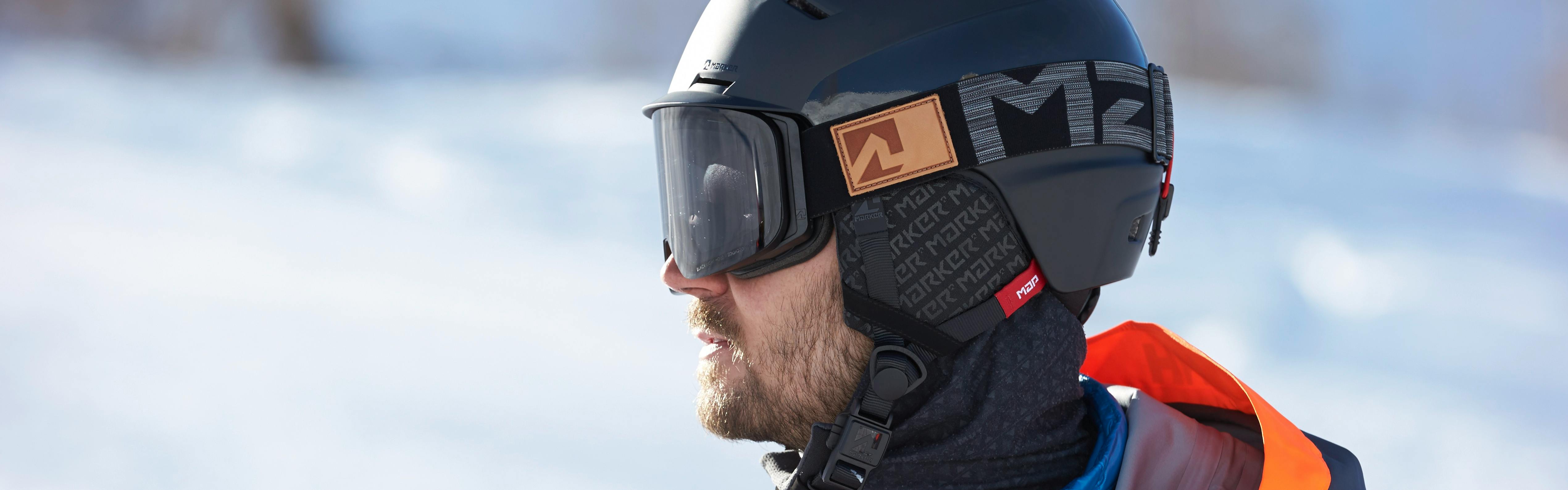 Closeup on a man wearing a black ski helmet and black ski goggles