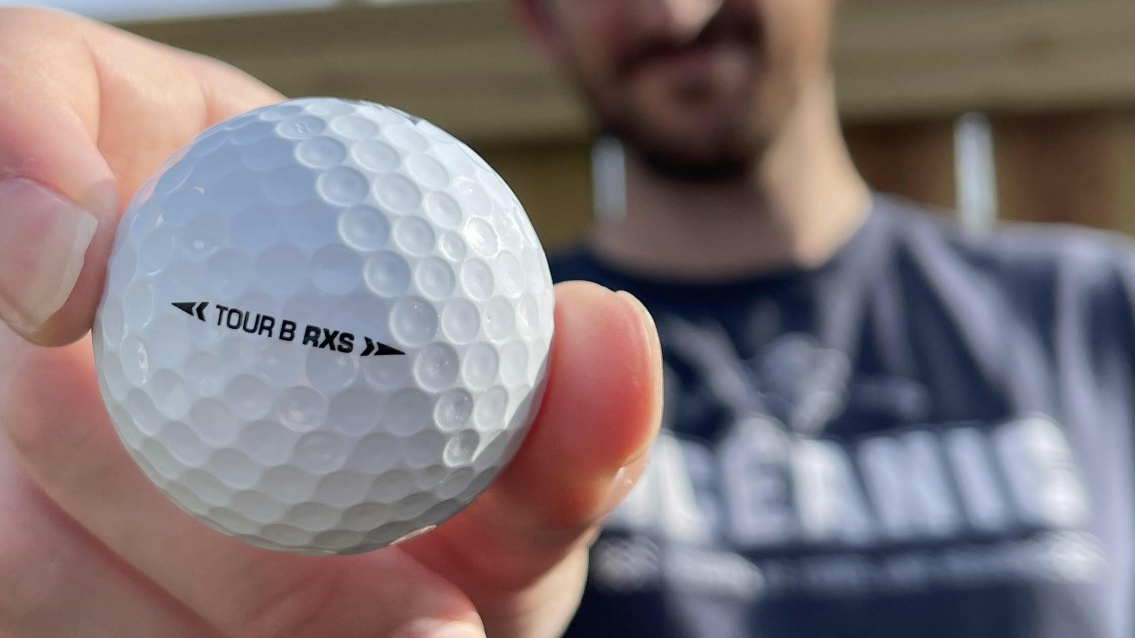 A man holding the Bridgestone 2022 Tour B RXS Golf Balls. 