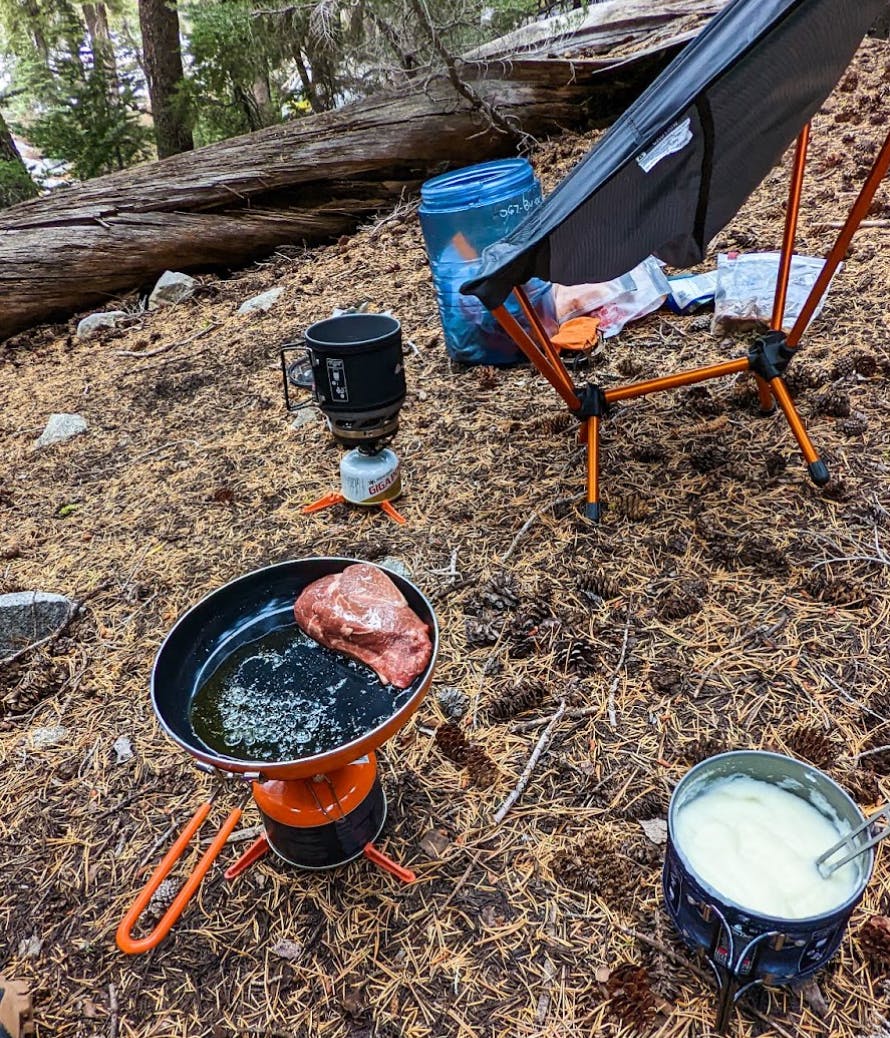 The Jetboil MiniMo Stove with a pan and some meat on it. 