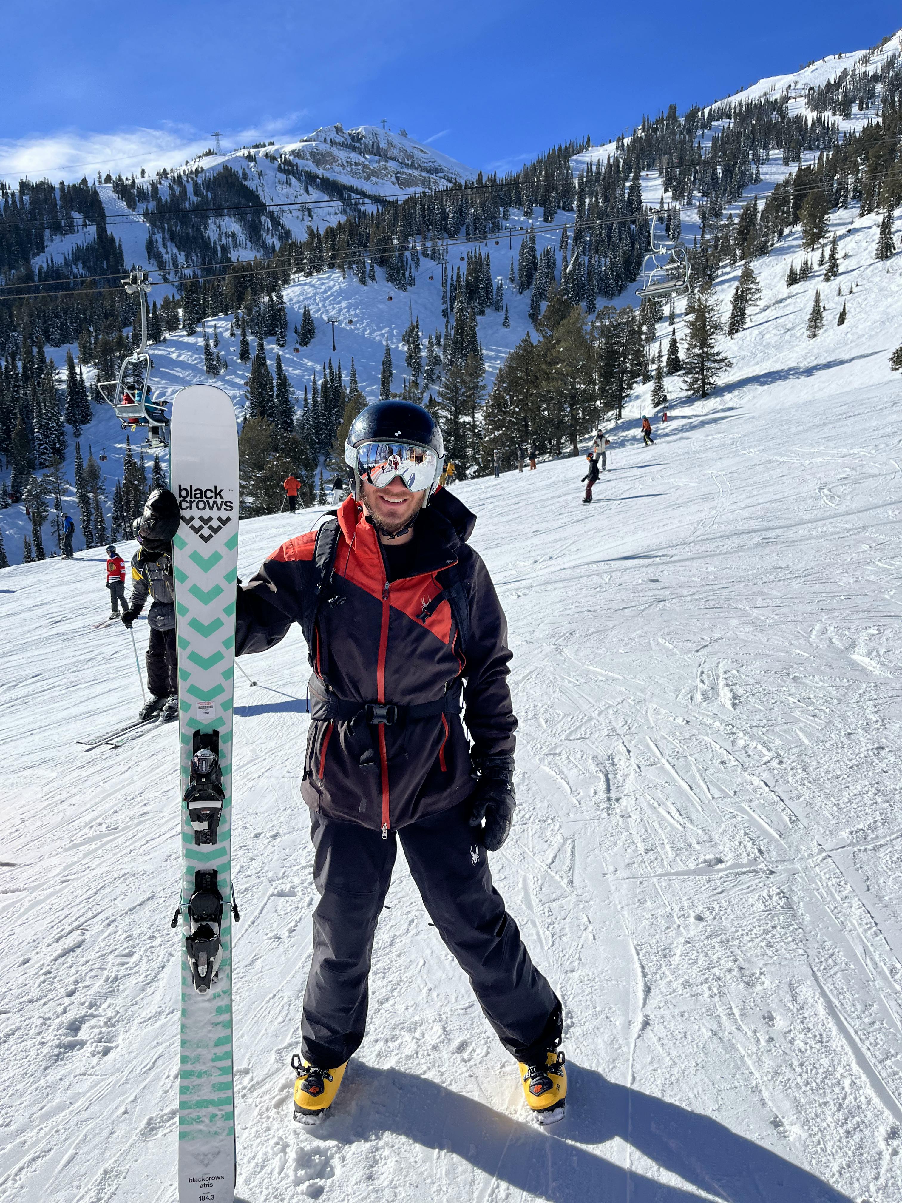 A skier holding the Black Crows Atris Skis · 2023. 