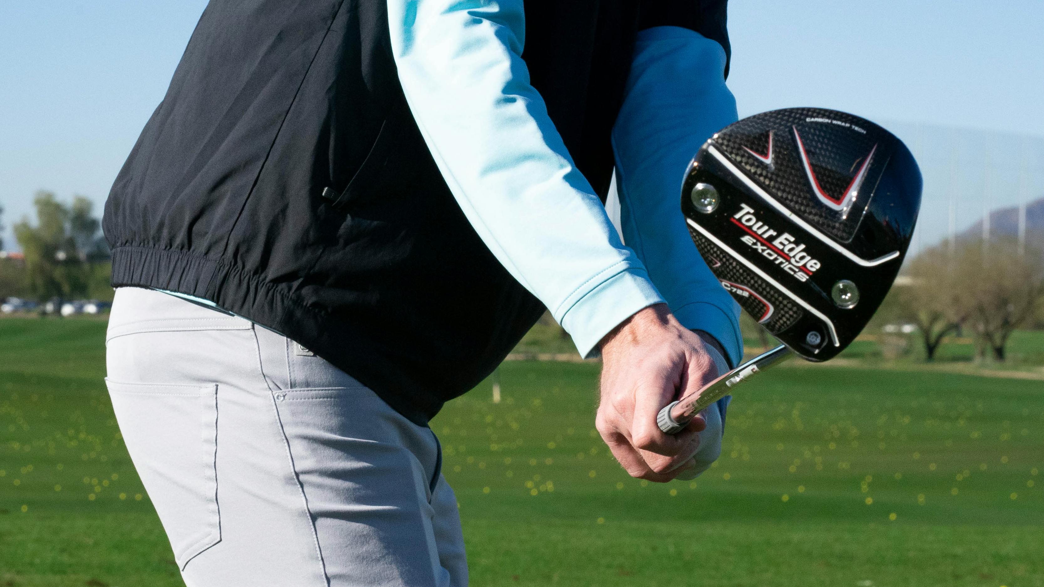 Person mid-backswing with a driver