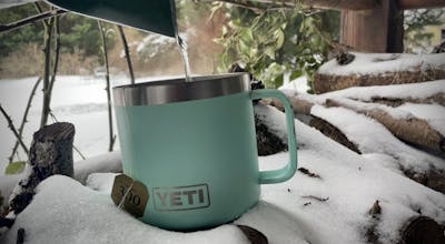 The author pours boiling water into her Yeti mug to make tea. 