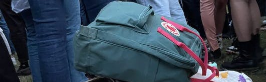 A Fjallraven Kanken Backpack in a pile of backpacks.