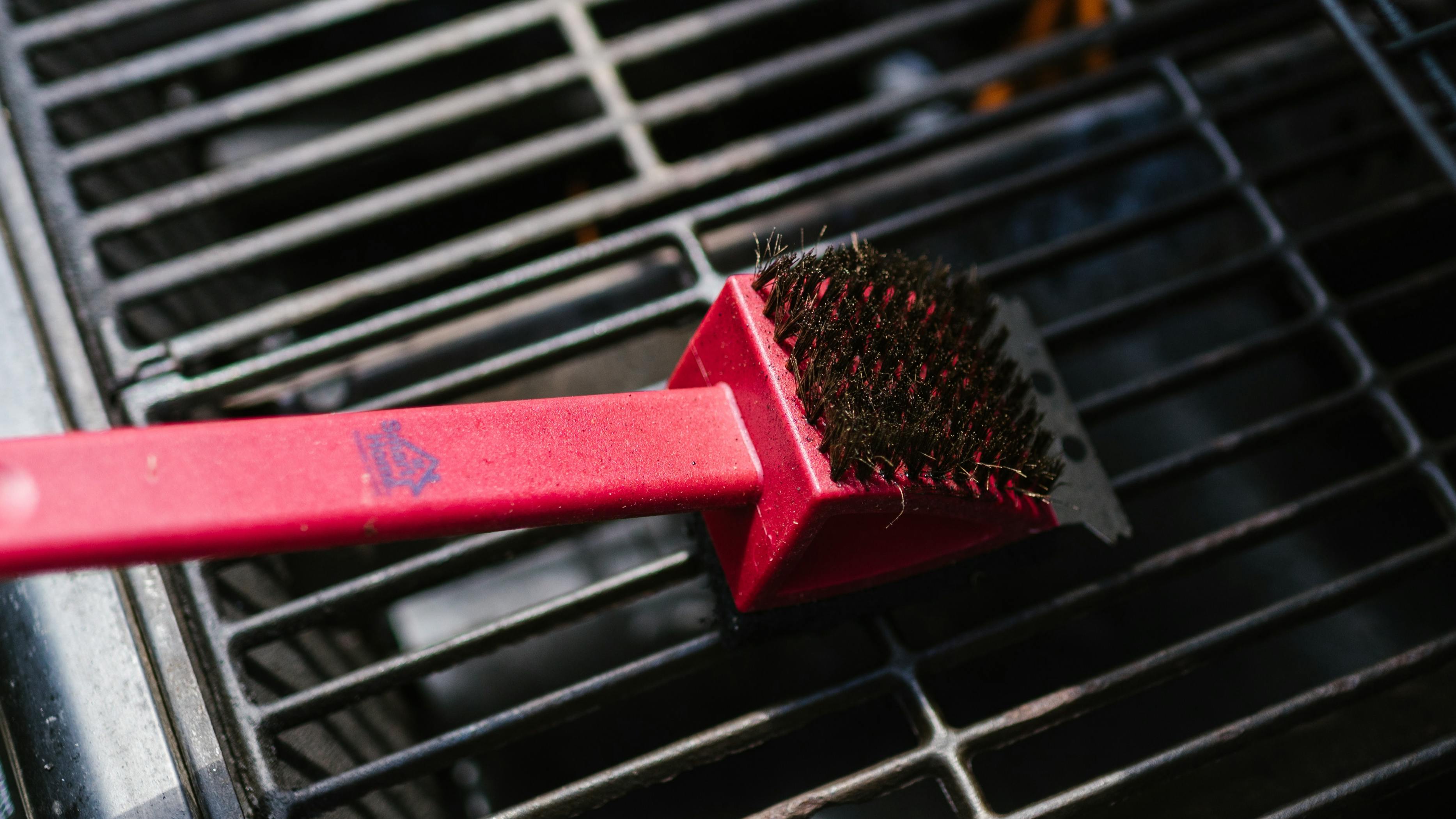 A brush scrubbing a grill. 