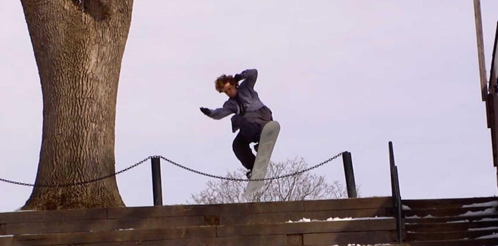 A snowboarder jumping on the Ride Agenda Snowboard.