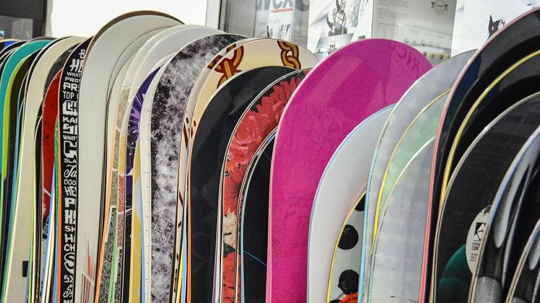 Several snowboards in a row at a store.