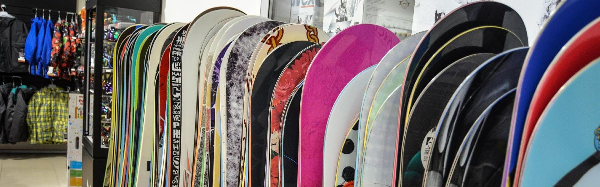 Several snowboards in a row at a store.