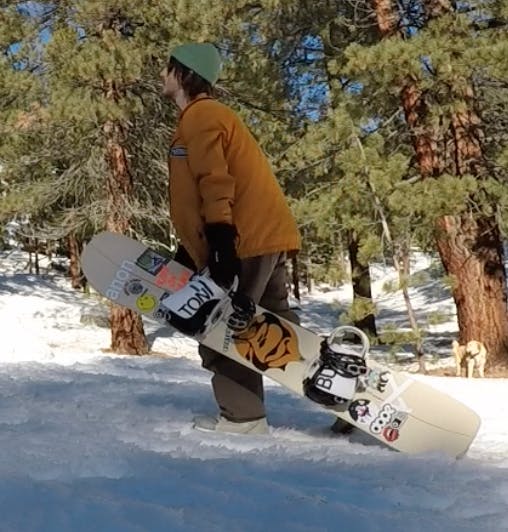 A snowboarder carrying a snowboard.
