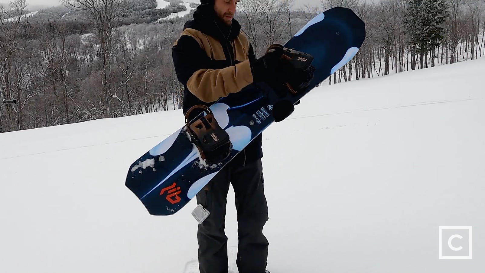 Curated expert Colby Henderson holding up the Lib Tech Orca snowboard
