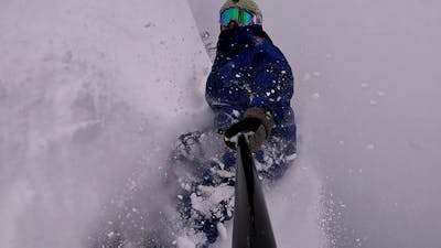 A selfie of a snowboarder in deep powder.