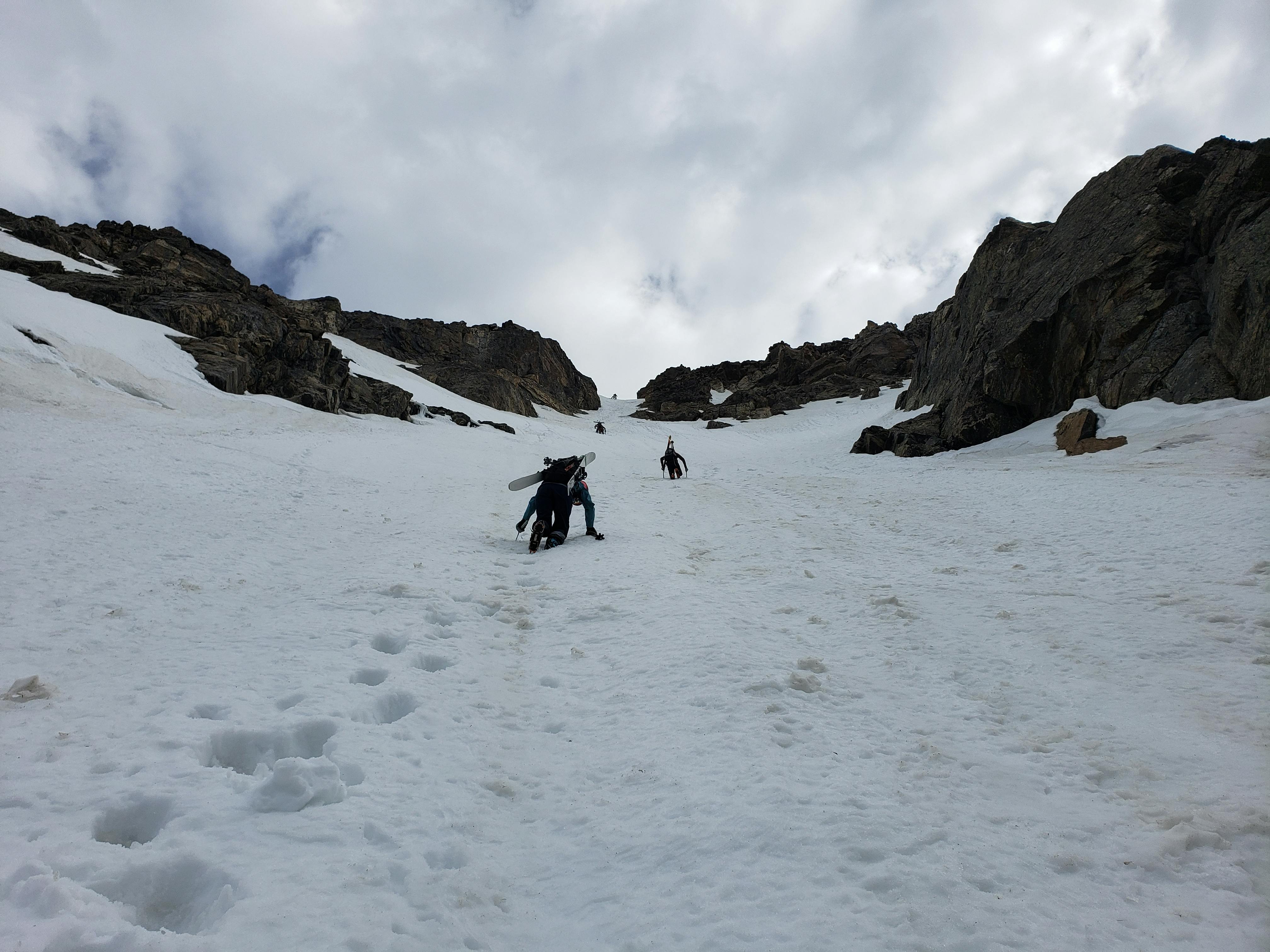 People climb up a snowy mountain