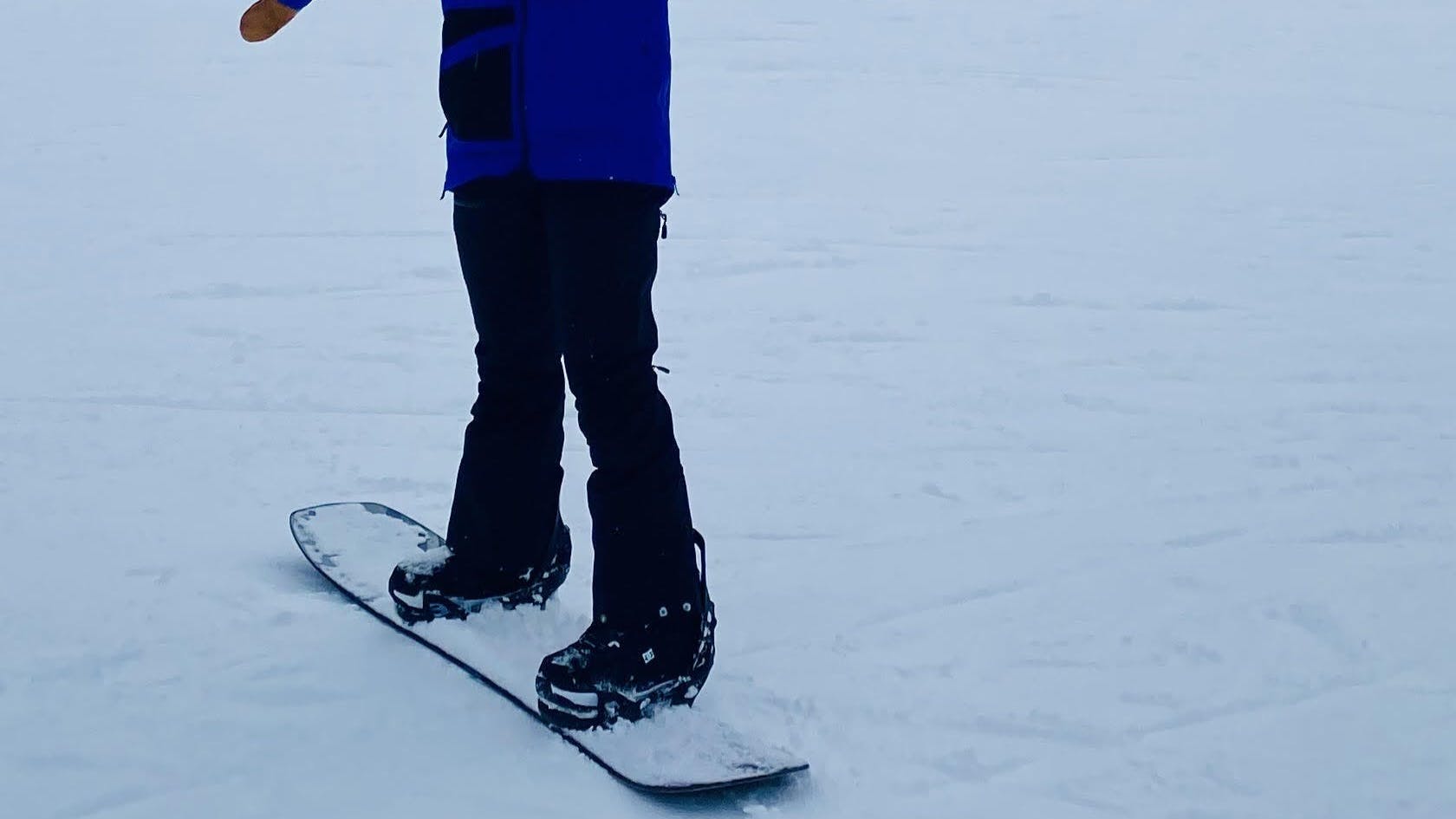 A snowboarder standing in the DC Lotus Step On boots on s ski run. 