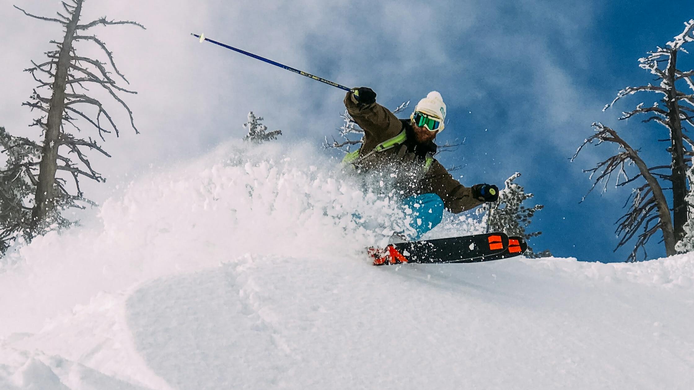 A skier turning over a snowy area with the bottom of his Armada skis visible. 
