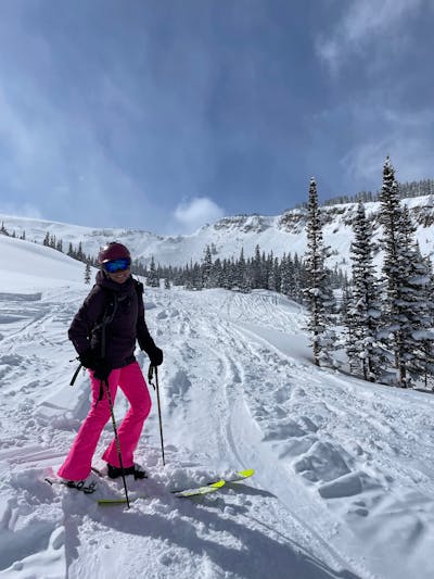 A woman standing on her K2 Mindbender 115C skis smiling. 