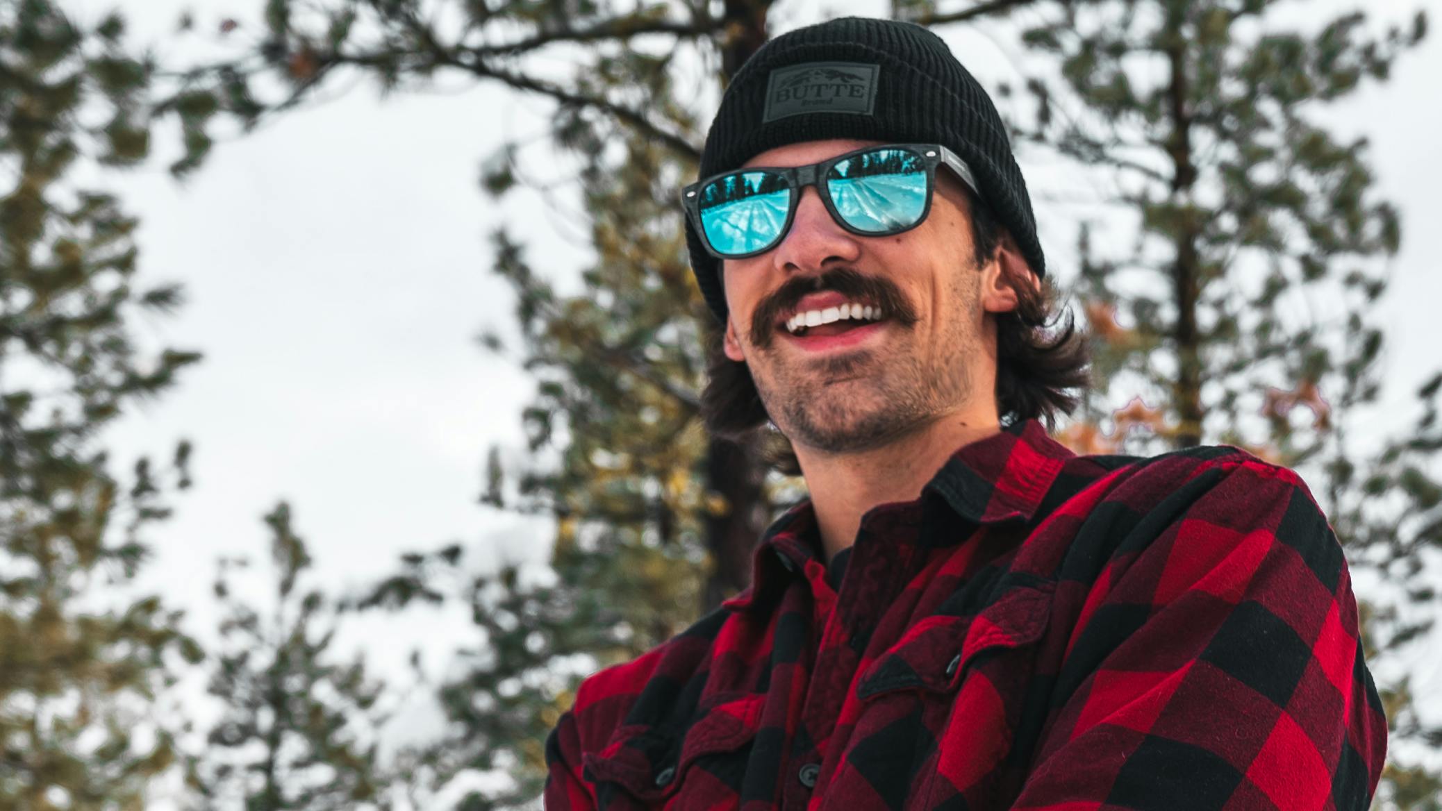 Curated expert Clay Ashworth in a red plaid shirt with the reflection of snow in his sunglasses