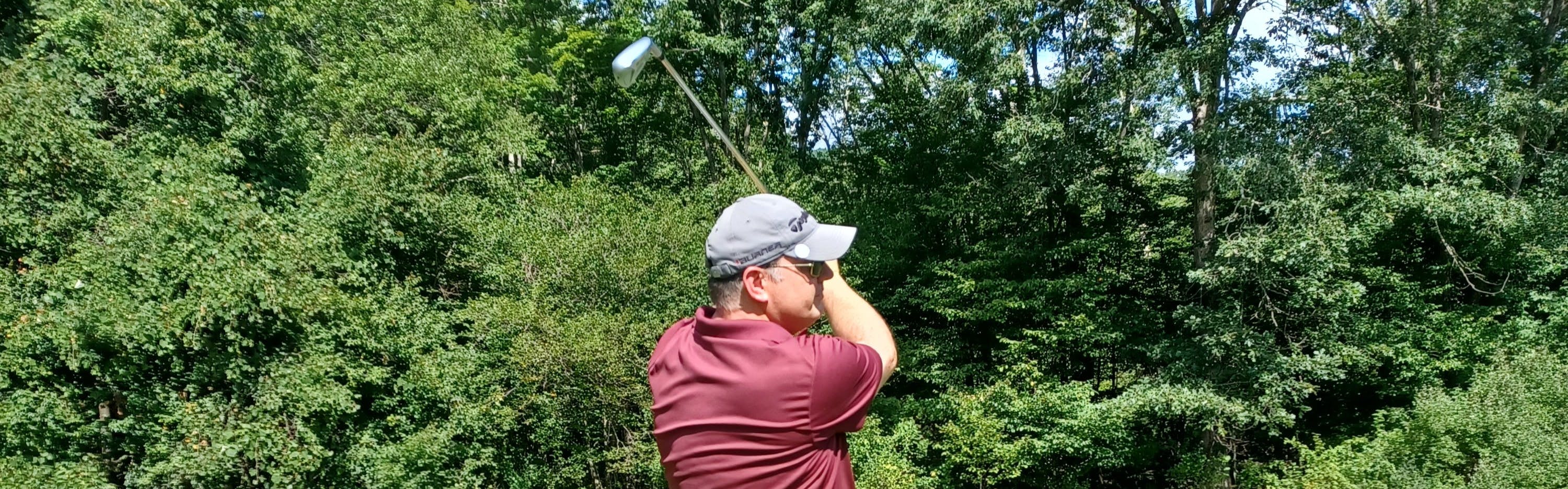 A man golfing with the Cleveland UHX Iron. 