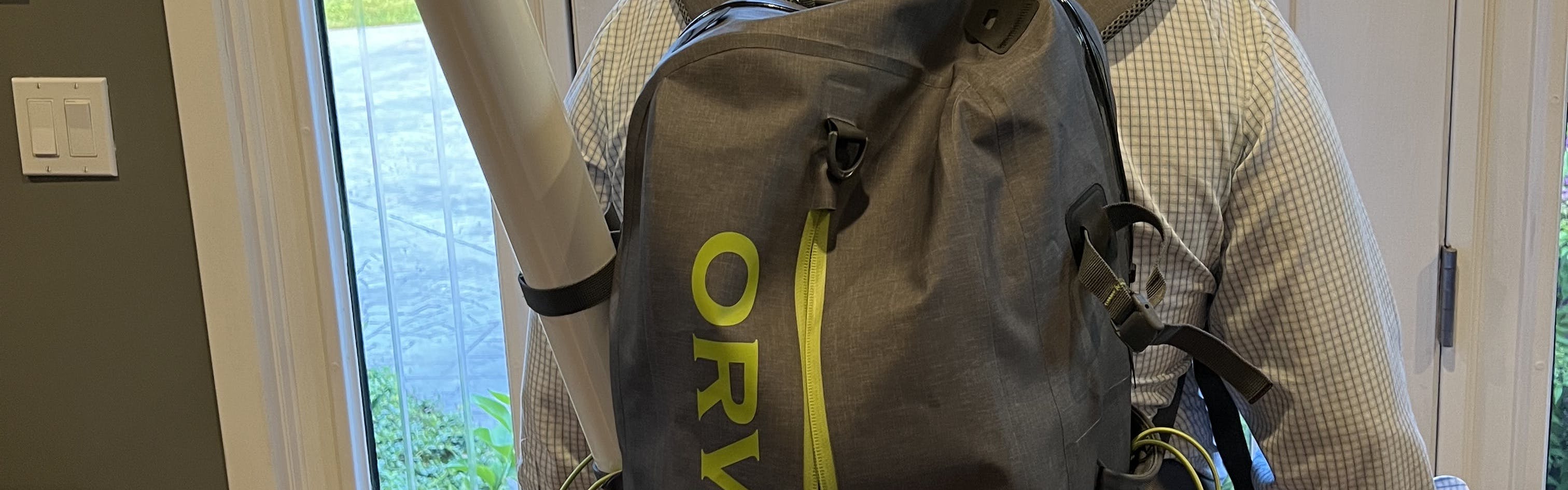 A man wearing the Orvis Waterproof Backpack.