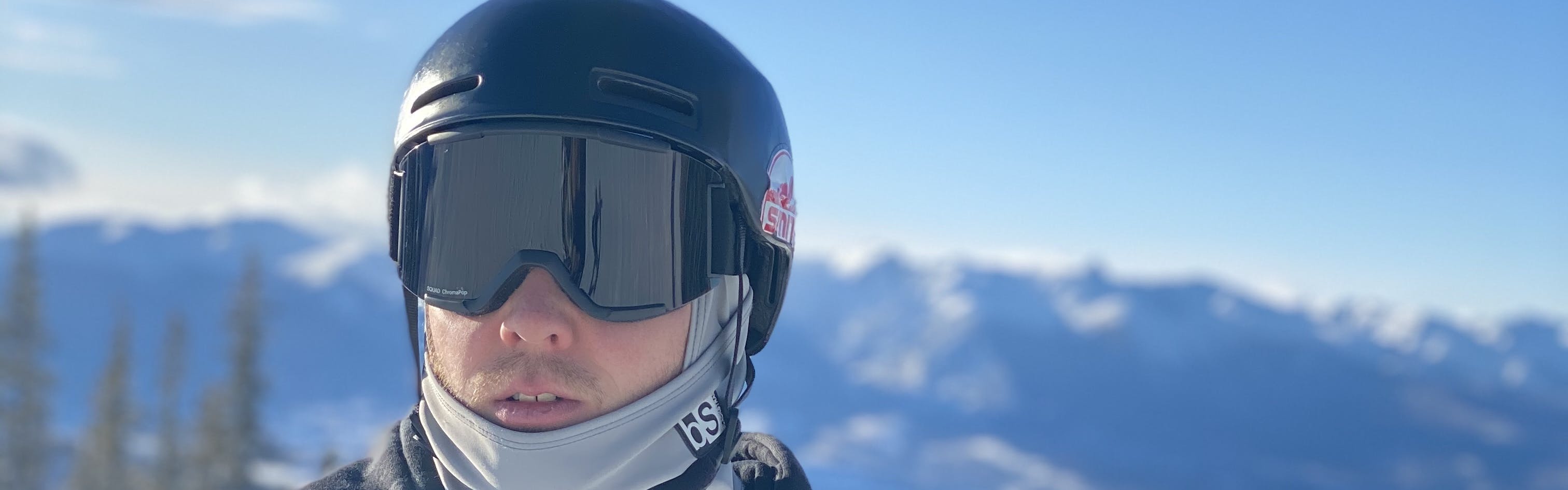 A skier wearing the Smith Maze MIPS Helmet with a snowy mountain range in the background. 