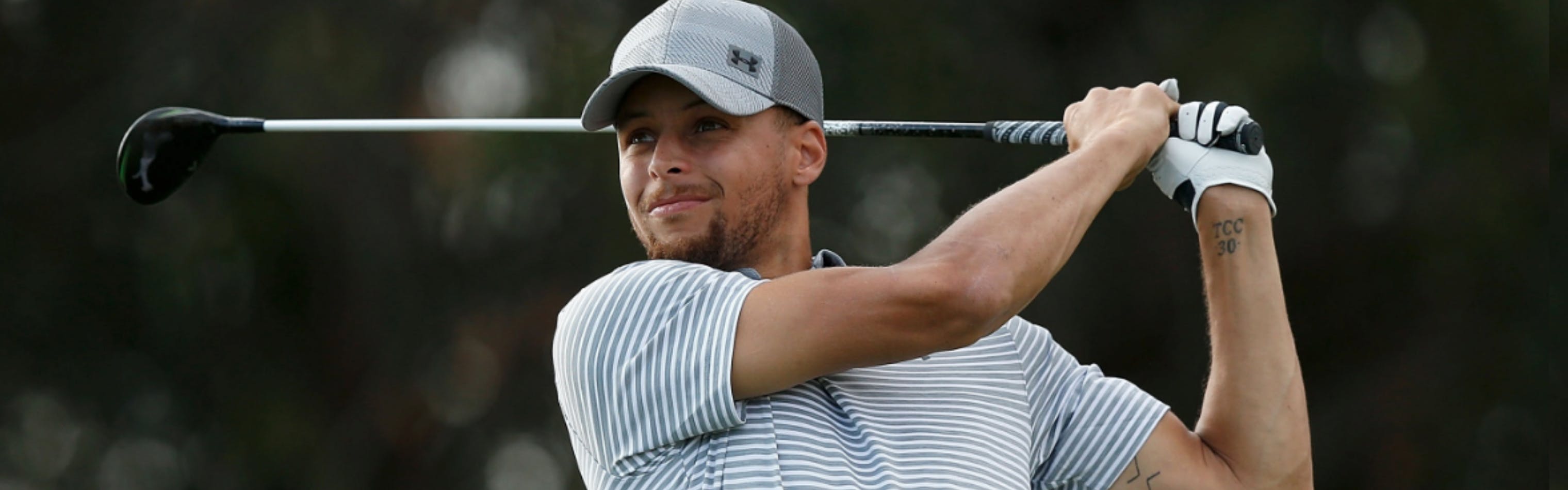 Golfer in a striped shirt swinging a golf club