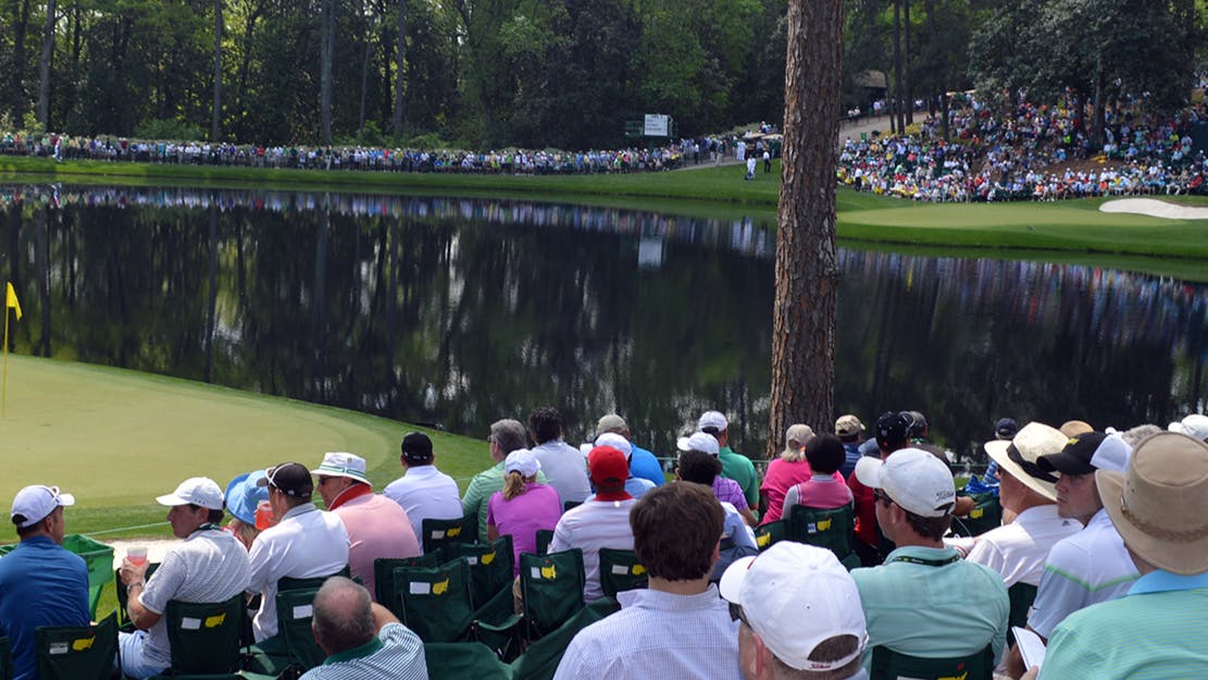 A group of spectators sit and watch the Masters.