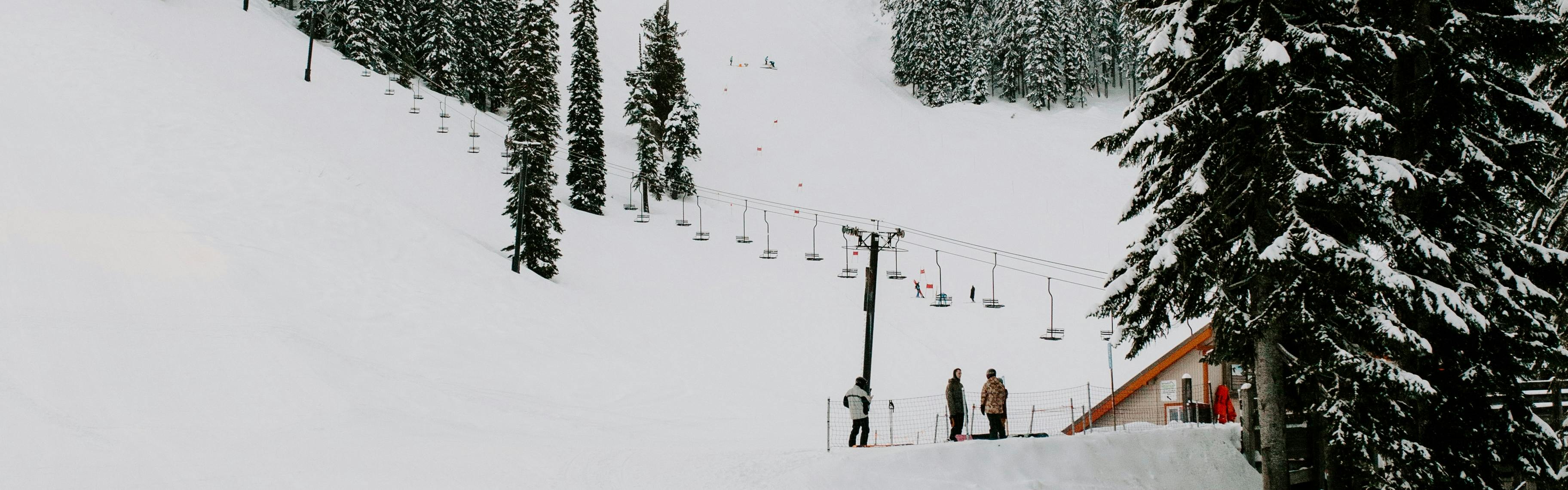 Several skiers at the bottom of a ski resort. 