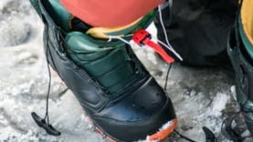 A person puts on snowboarding boots