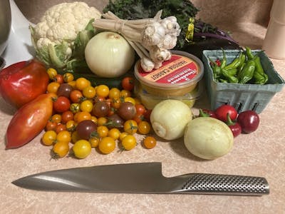 The Global Classic Chef's Knife next to several different types of vegetables. 