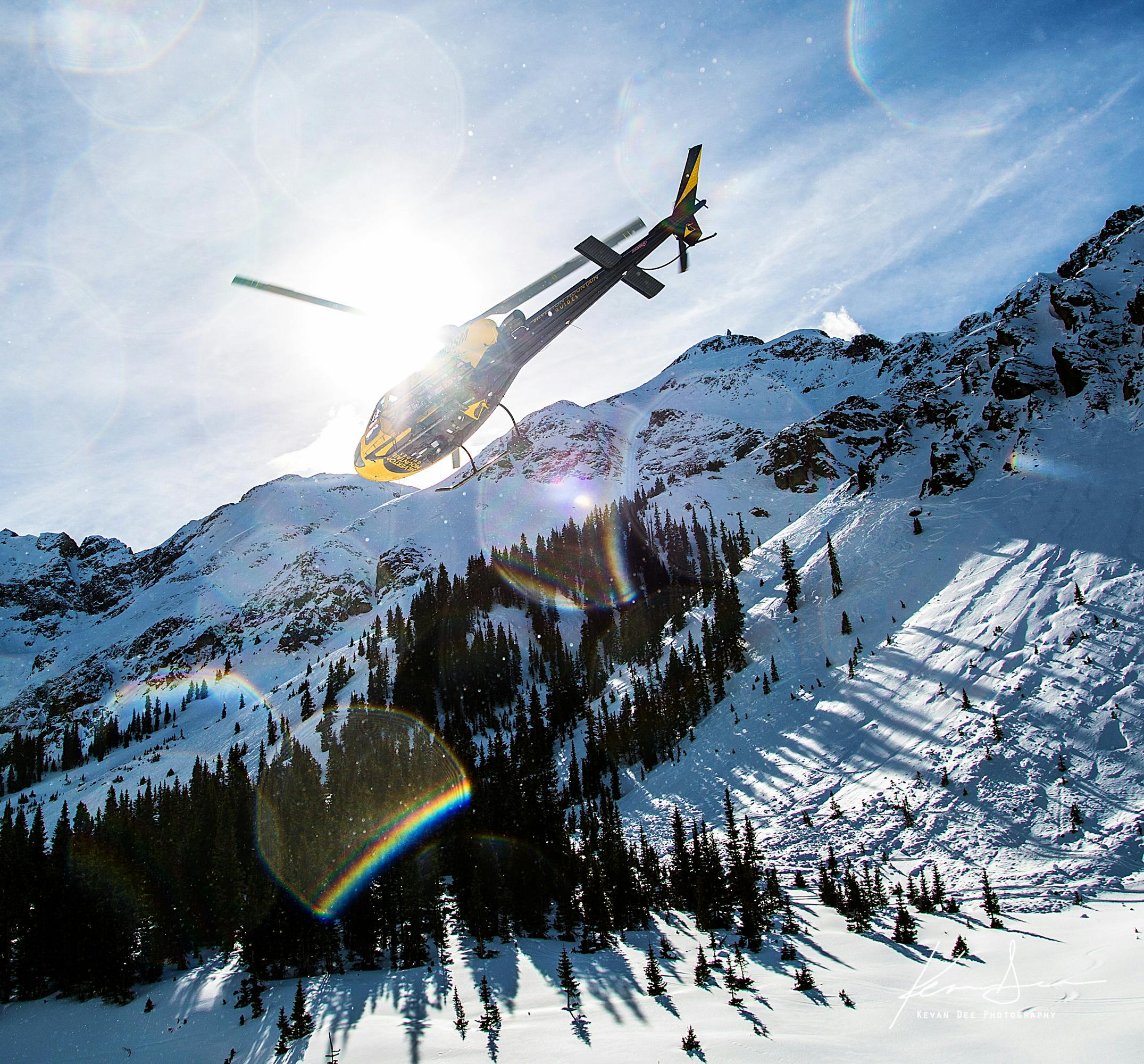 A helicopter takes off from a mountain.