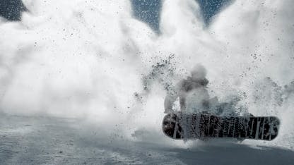 A snowboarder in a cloud of powder