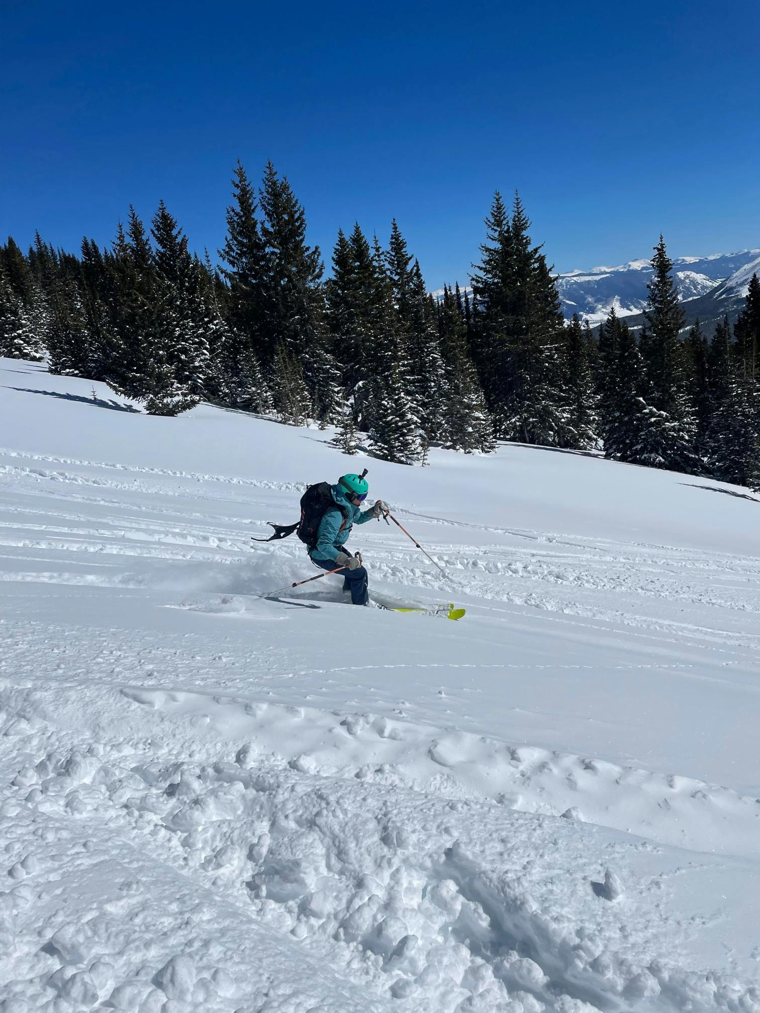 A skiing woman turns down a snowy run.