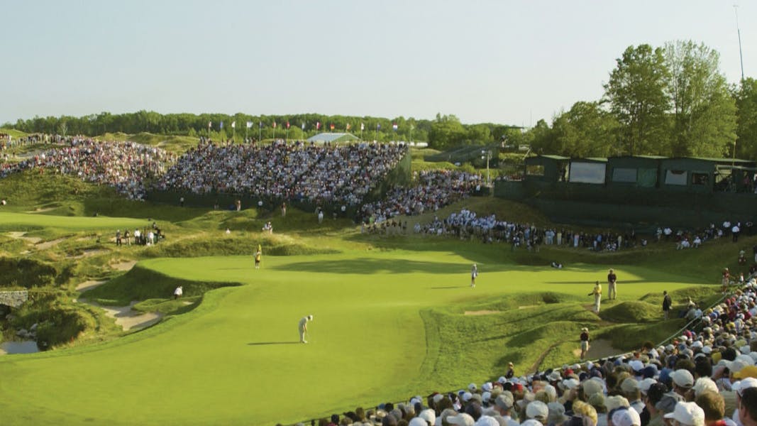 The course at Whistling Straits with crowds in stands watching the golfers.
