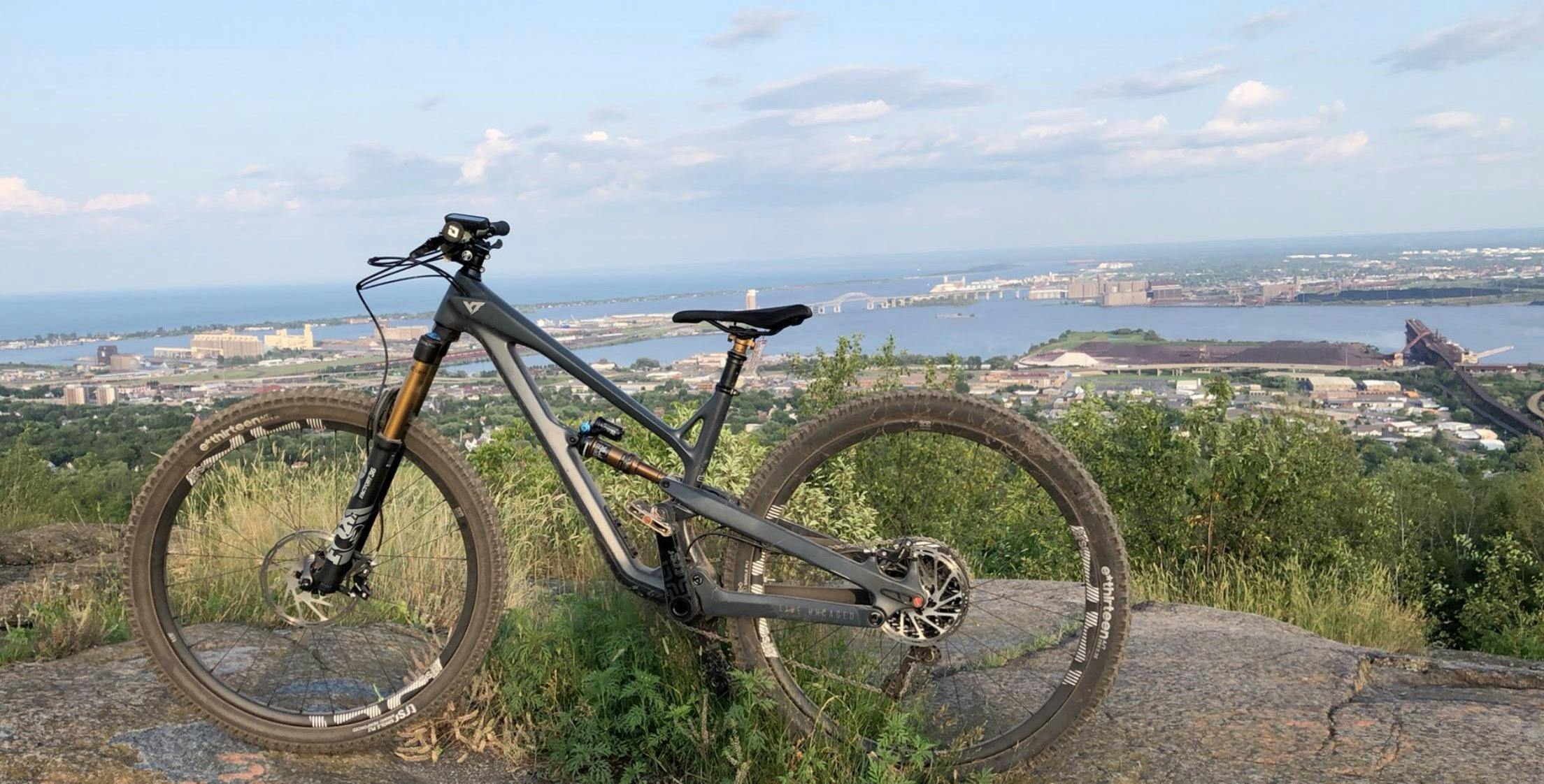 A Pro Race bike sits at an overlook with a body of water and trees in the background.