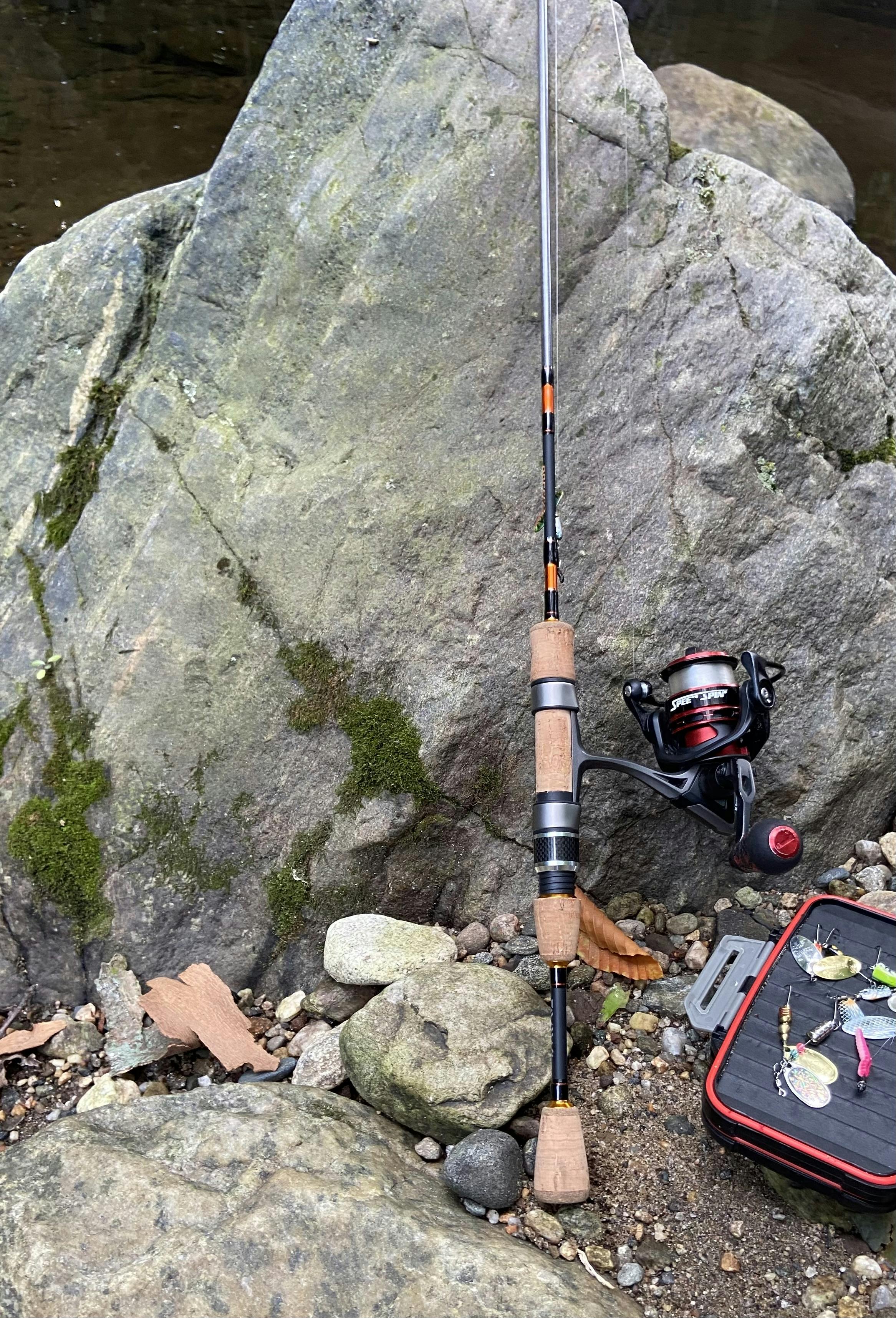 Daiwa Presso 5'6" Ultralight Spinning Rod, Lew's Carbon Fire Spinning Reel, Sunline Sniper 2lb leaning against a rock. 