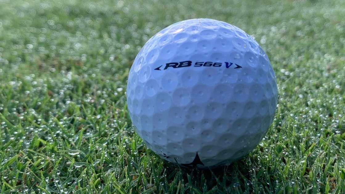 A Mizuno RB 566V Golf Ball lying on the grass.