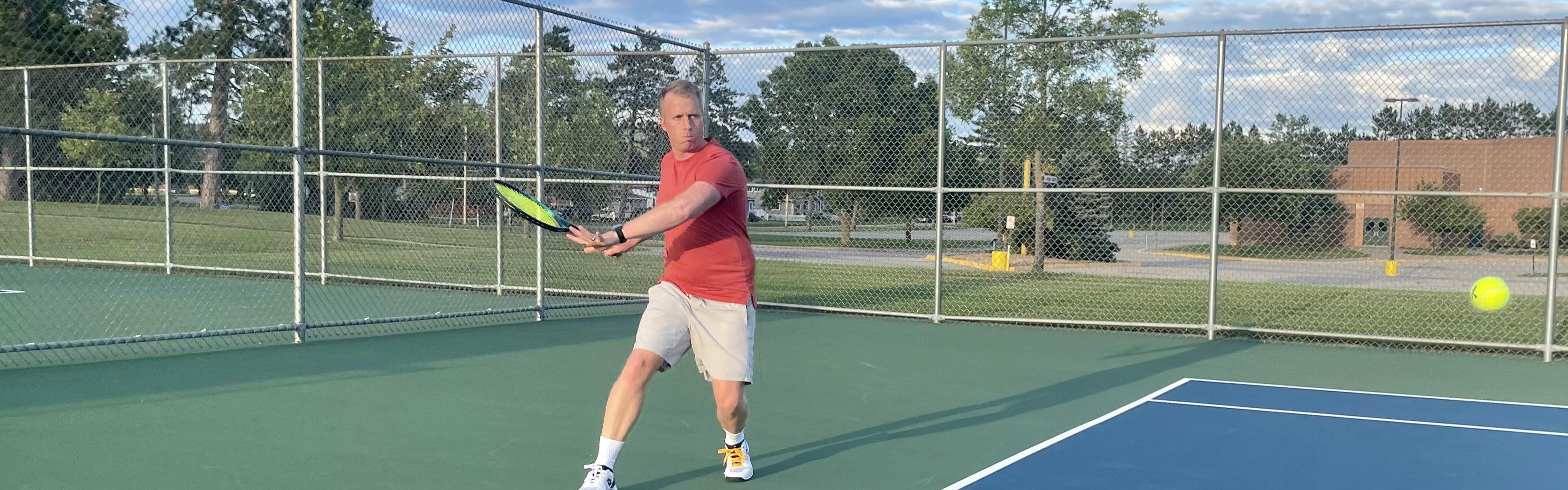 A man on a tennis court uses the Yonex VCORE Pro 97 Racquet.