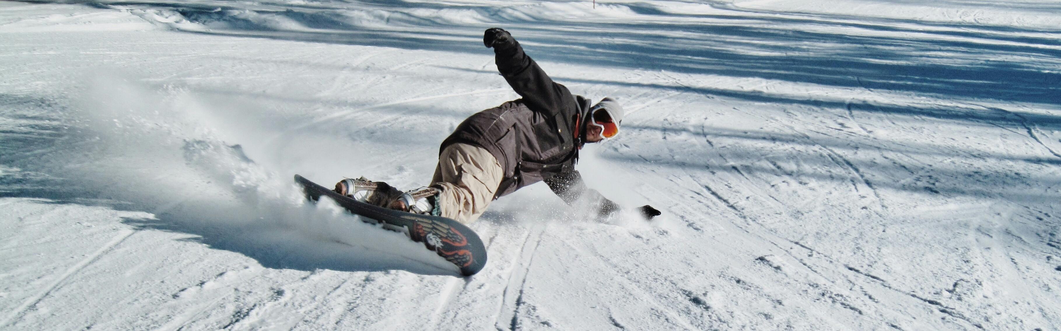 A snowboarder executes a hard turn