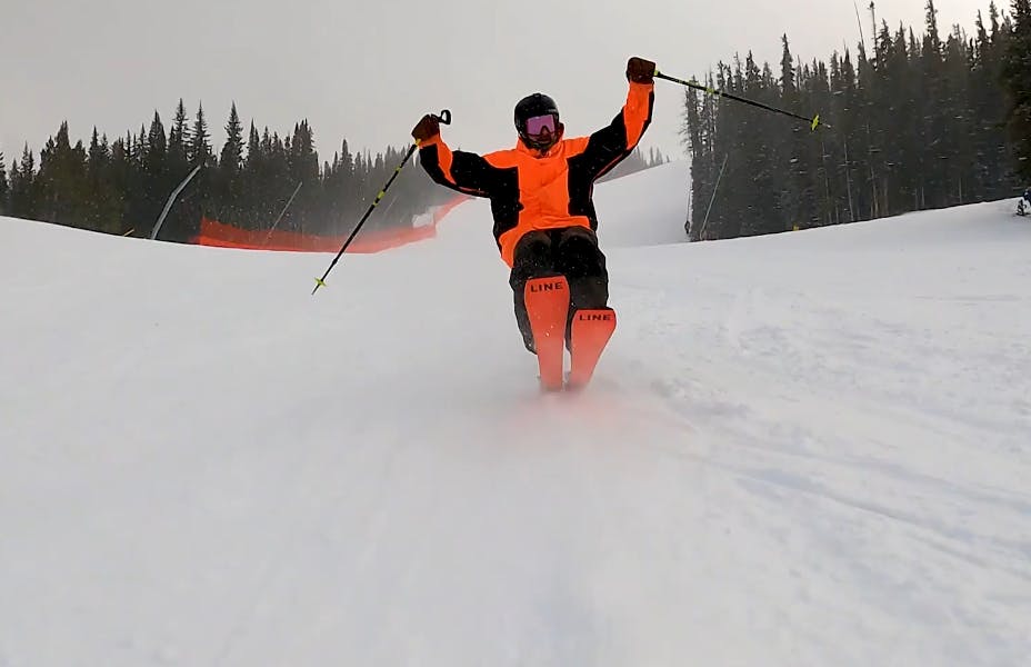 A skier doing a jump and leaning on the tail of his skis. 
