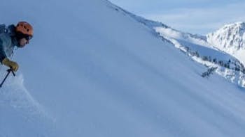 A man skiing down a snowy mountain. 