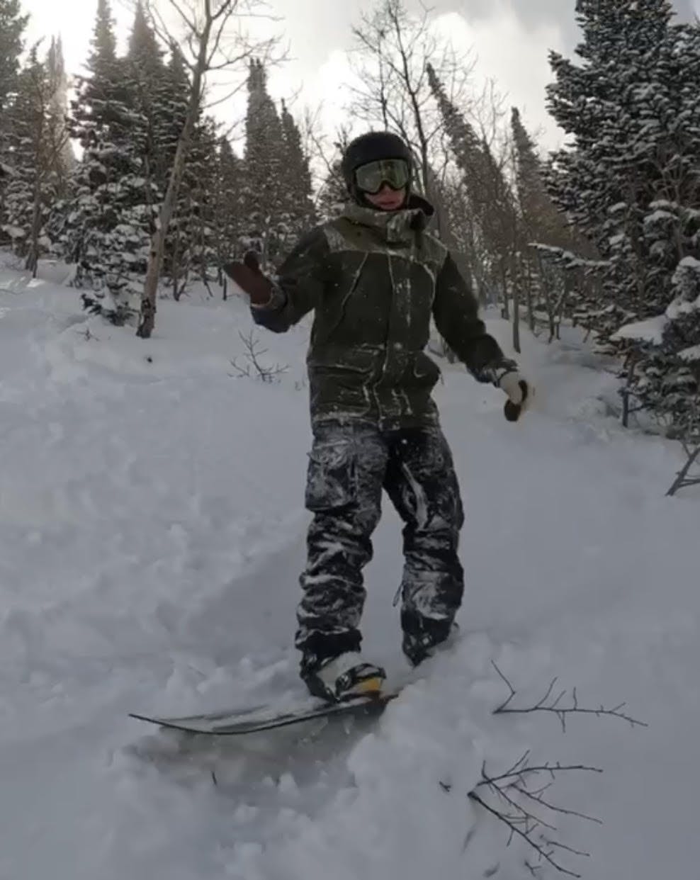 A snowboarder covered in snow and wearing the Burton Men's Covert Pants.