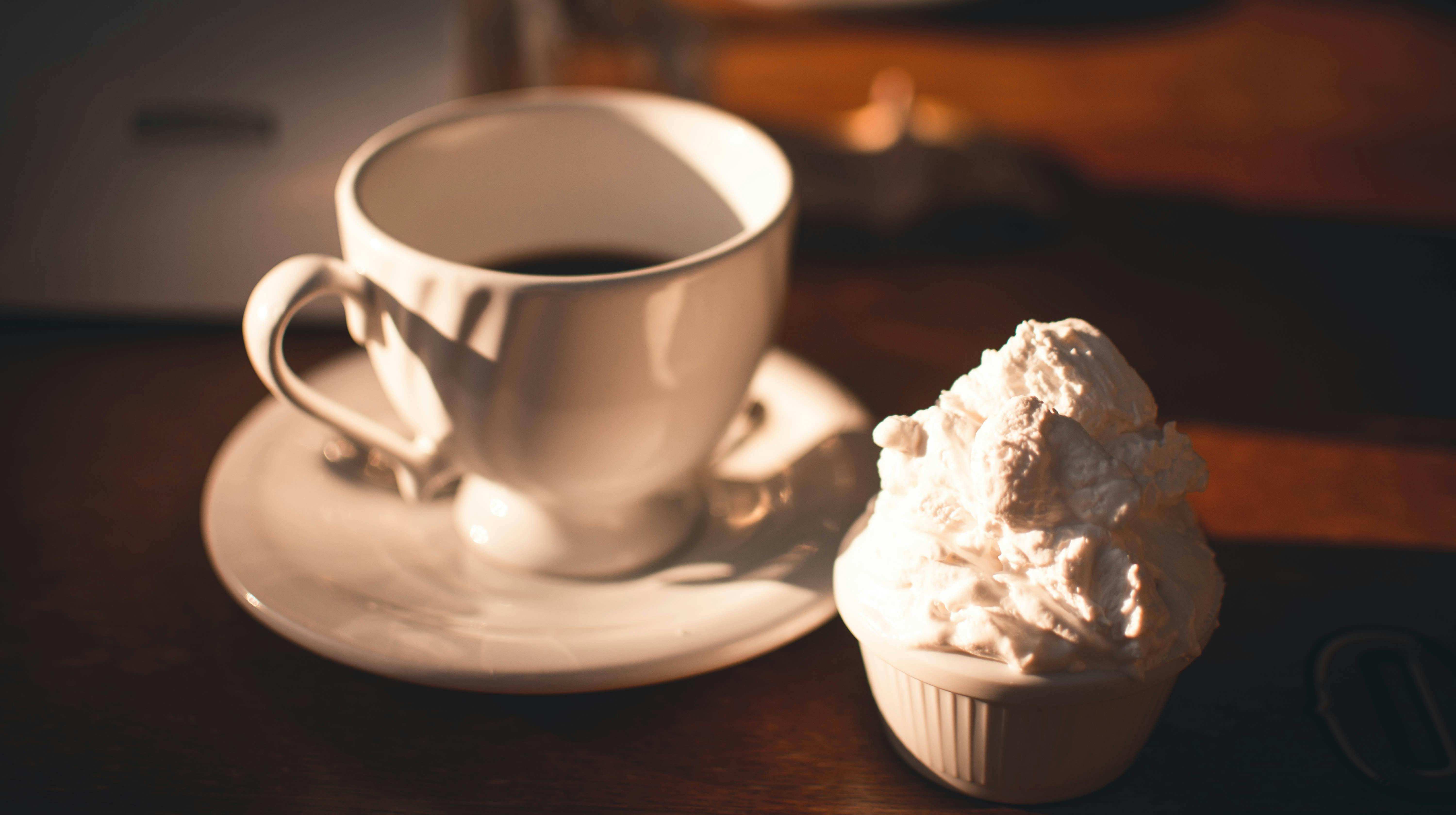 A single shot of espresso served in a demitasse glass with a dollop of fresh Chantilly cream served in a ramekin