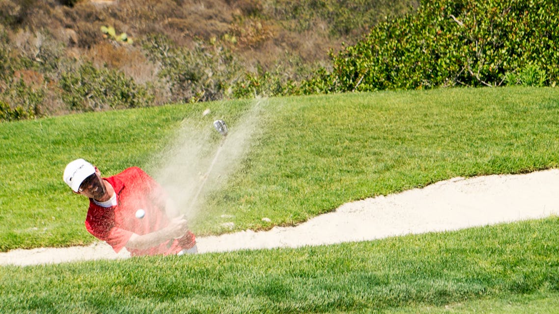 Golfer at Torrey Pines hitting a ball out of a bunker