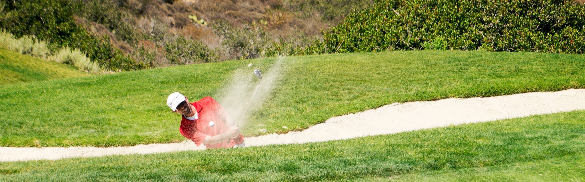 Golfer at Torrey Pines hitting a ball out of a bunker
