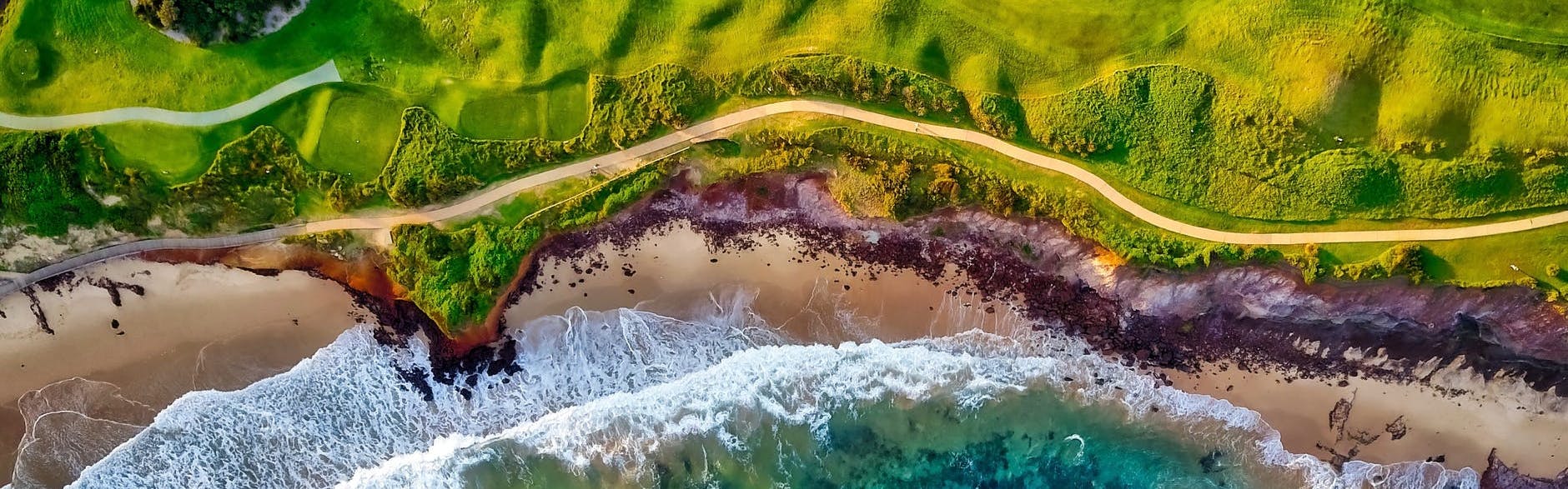 The edge of a golf course meets the ocean
