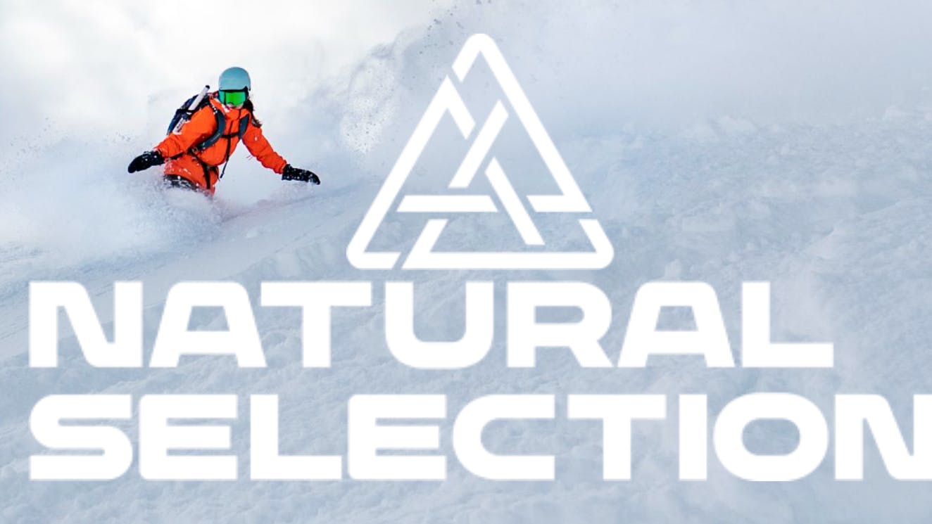 A snowboarder in orange rides downhill next to the Natural Selection logo.