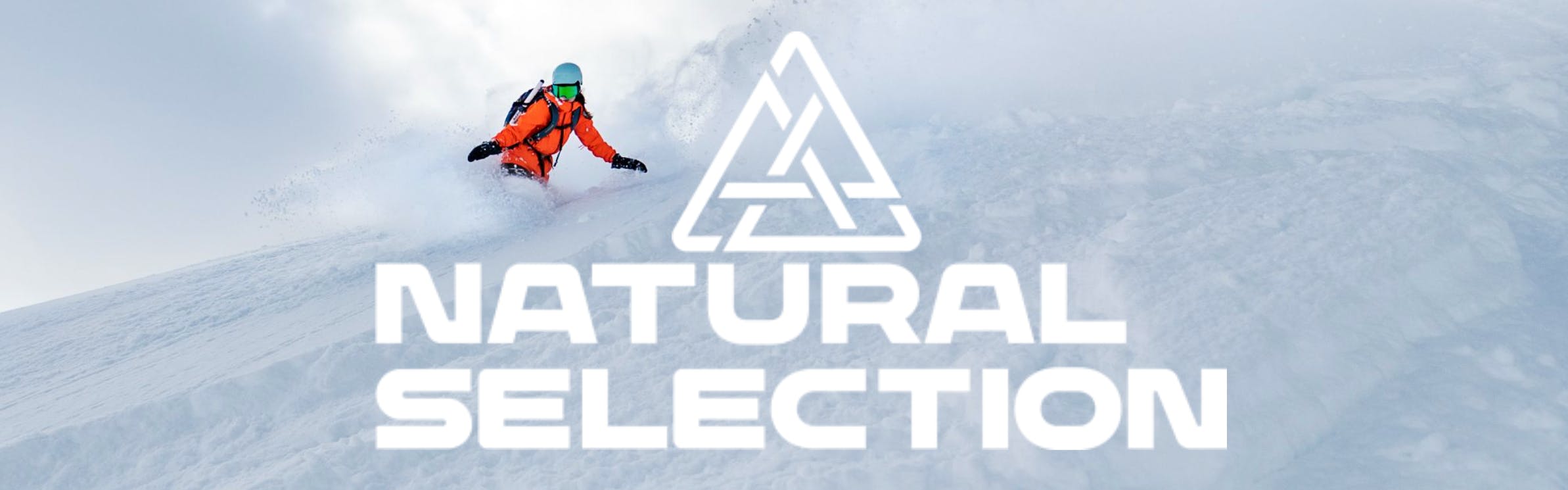 A snowboarder in orange rides downhill next to the Natural Selection logo.