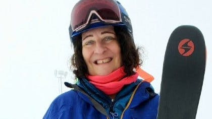 A woman in ski gear smiling and holding the Blizzard Bonafide 97 skis. 