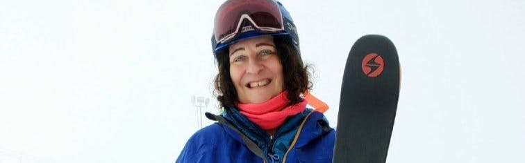 A woman in ski gear smiling and holding the Blizzard Bonafide 97 skis. 