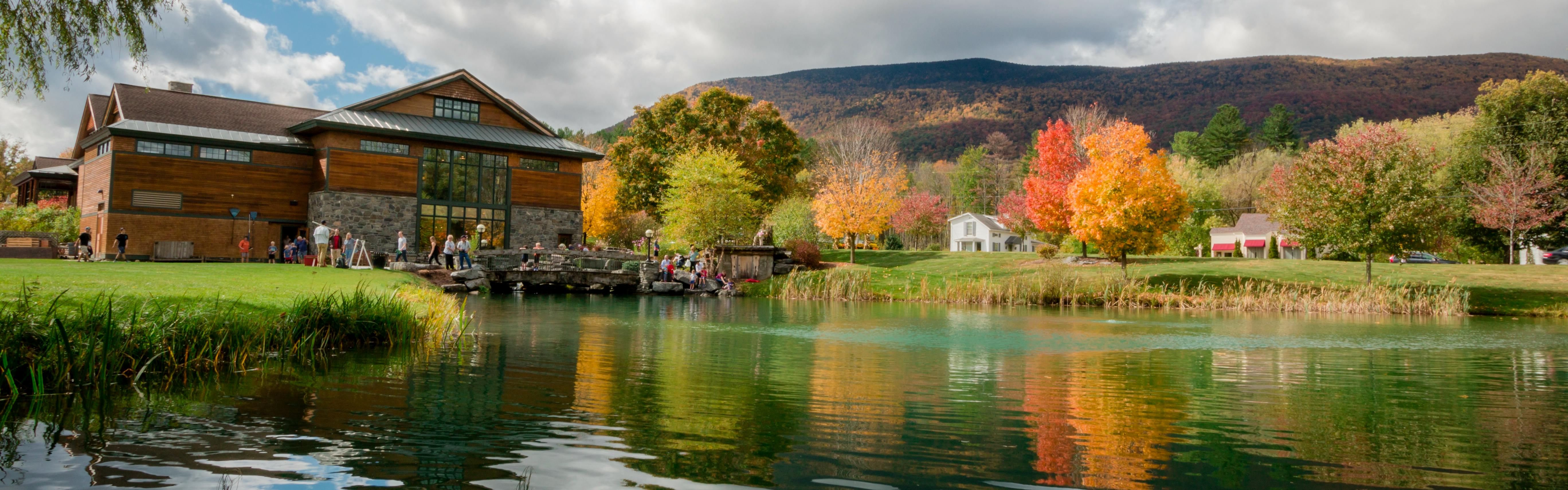 The Orvis store in Manchester on the edge of a lake surrounded by bright red and yellow autumn foliage