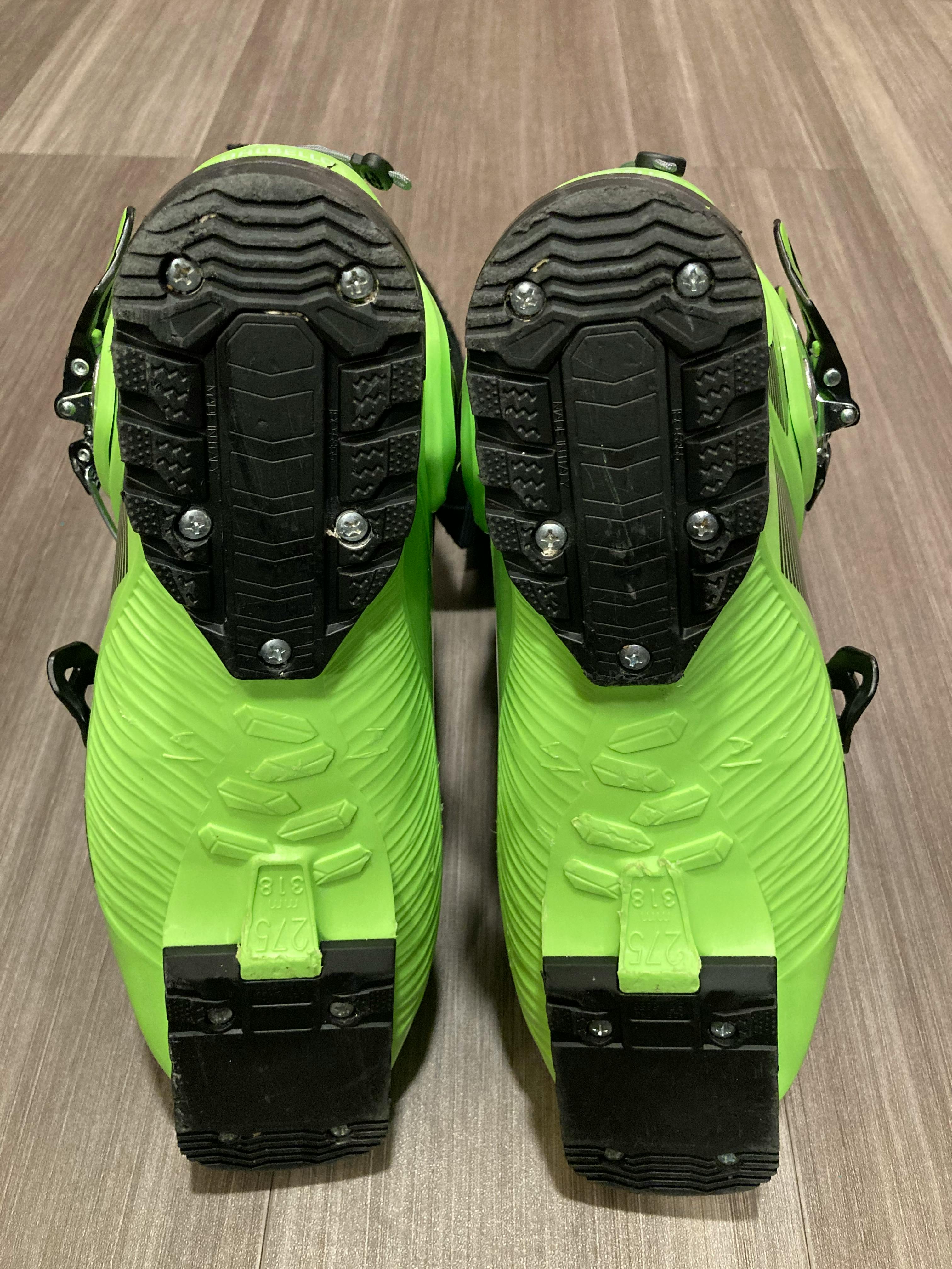 The bottom of a pair of lime green and black ski boots