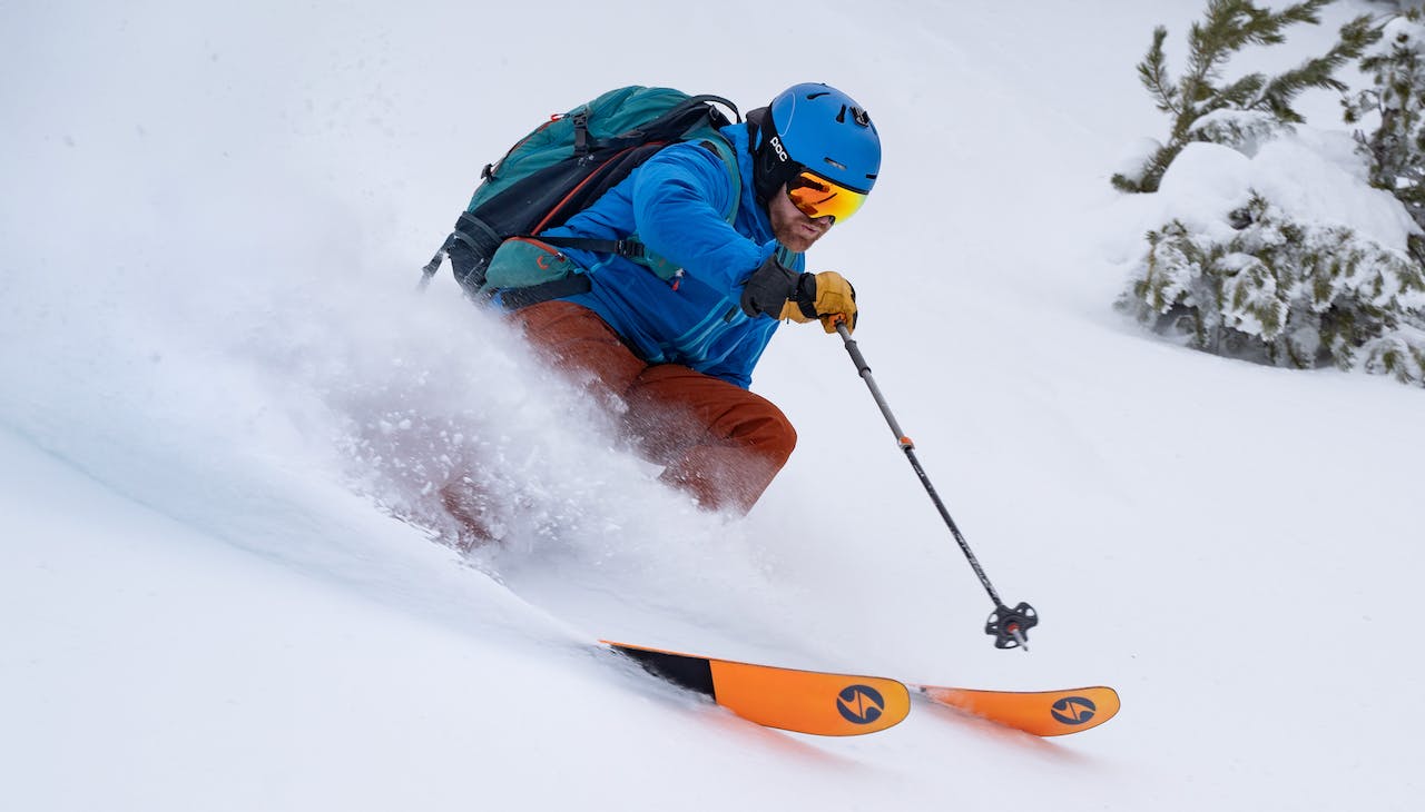 A skier turning down a snowy mountain on his Blizzard skis. 